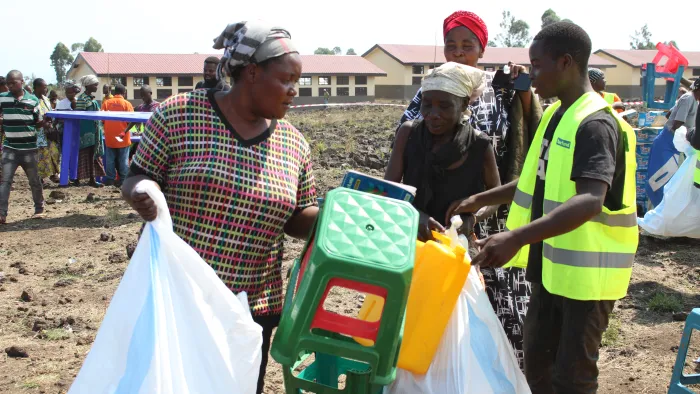 A woman collects non-food items and puts them in a large bag during a response.