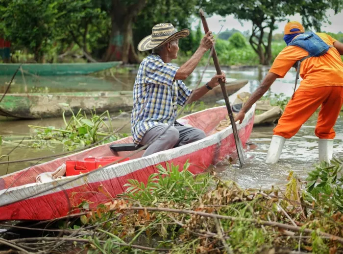 Man in a boat with a humanitarian worker assisting him