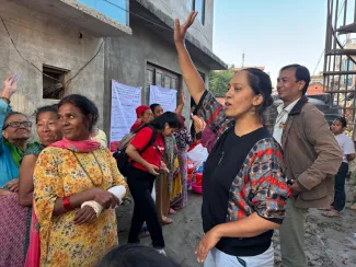 A woman holds up her hand during a briefing about the transparency board in Bansighat, Kathmandu.