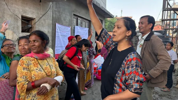 A woman holds up her hand during a briefing about the transparency board in Bansighat, Kathmandu.