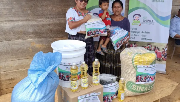 Une femme remet des colis de nourriture à une famille au Guatemala, en prévision d'un ouragan.